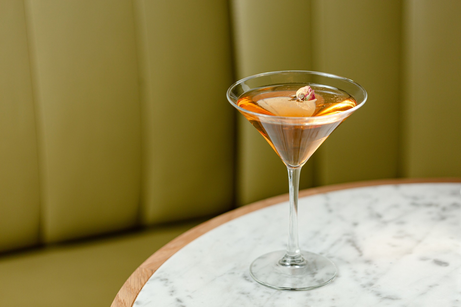 Glass cocktail garnished with flowers